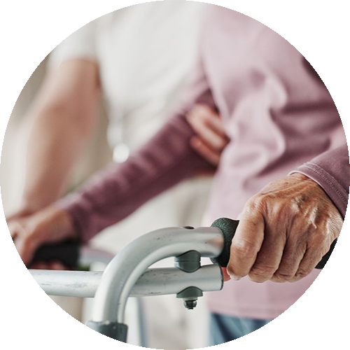 Ältere Person trainiert Gleichgewicht auf einer Matte mit Unterstützung eines Therapeuten.